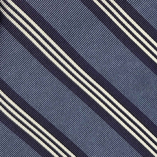 Cravate régimentaire en soie jacquard faite main en Italie avec rayures bleu métallisé et bleu marine, à découvrir dans la boutique de vêtements à Genève